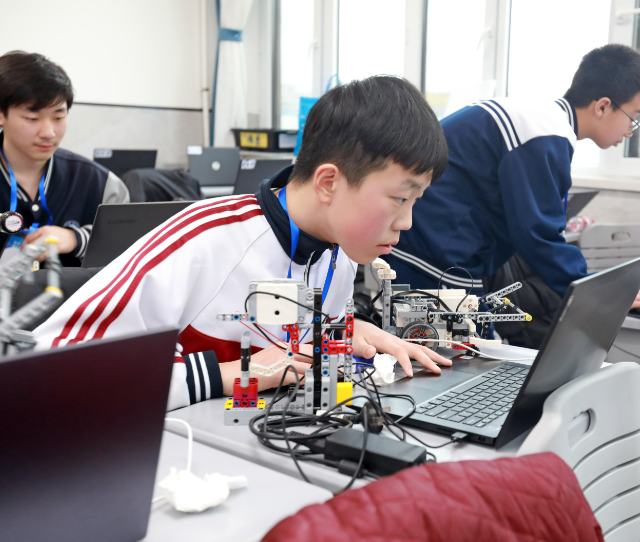 学生们手持一个“口袋乌龟然后将其放在涂有不同色彩的纸上 学生们手持一个“口袋乌龟然后将其放在涂有不同色彩的纸上